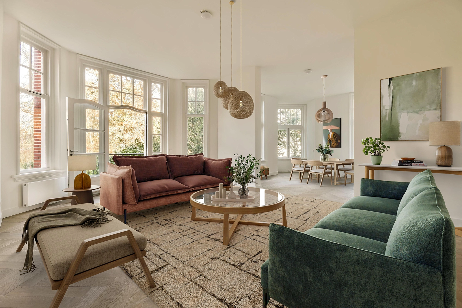 A bright, elegant living-dining space featuring large sash windows, a terracotta sofa and green velvet counterpart, anchored by a soft geometric rug and a round wooden coffee table. Natural textures, indoor plants, and soft lighting add warmth and sophistication throughout. - After